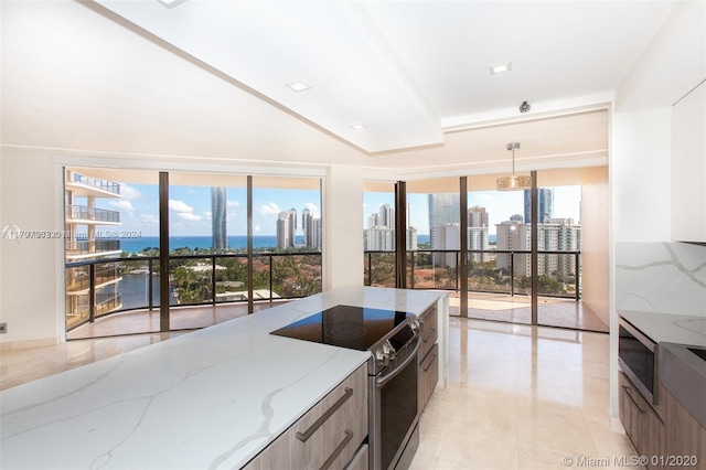 kitchen with light stone countertops, backsplash, pendant lighting, electric stove, and a water view