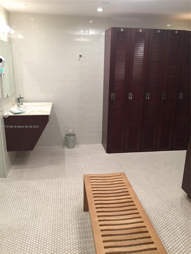 bathroom with vanity and tile walls