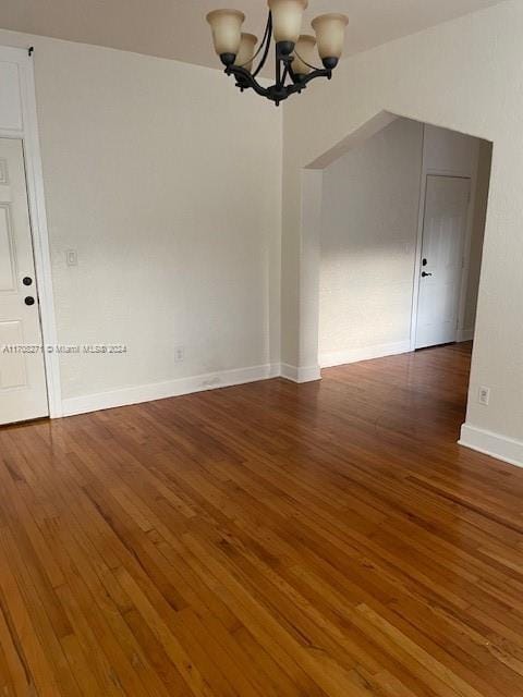 interior space with a notable chandelier and dark hardwood / wood-style flooring