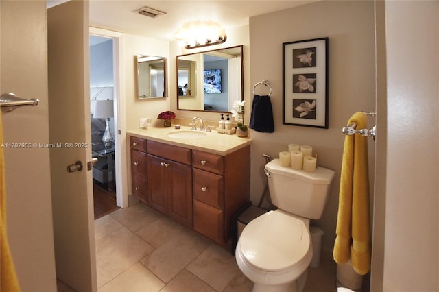 bathroom with tile patterned flooring, vanity, and toilet