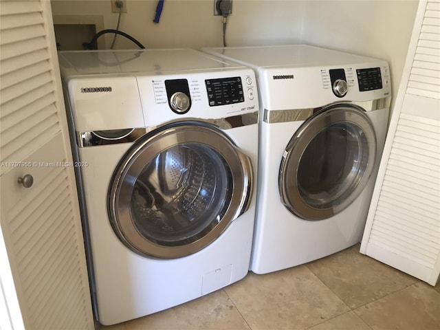 laundry room featuring light tile patterned flooring and washing machine and dryer