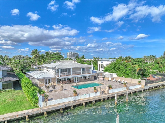 rear view of house with outdoor lounge area, a water view, a pool with hot tub, a balcony, and a patio area