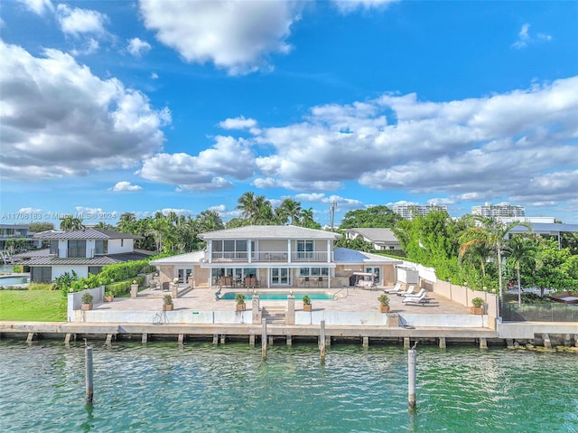 rear view of house featuring a water view, a balcony, a patio, and a pool