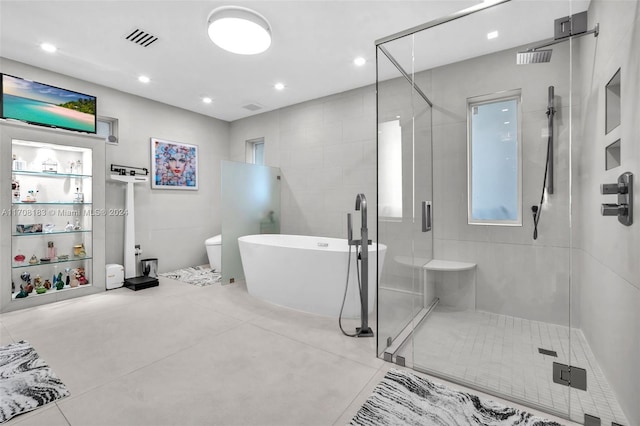 bathroom with toilet and shower with separate bathtub