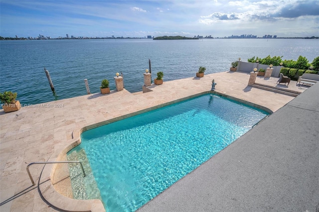 view of pool featuring a water view and a patio