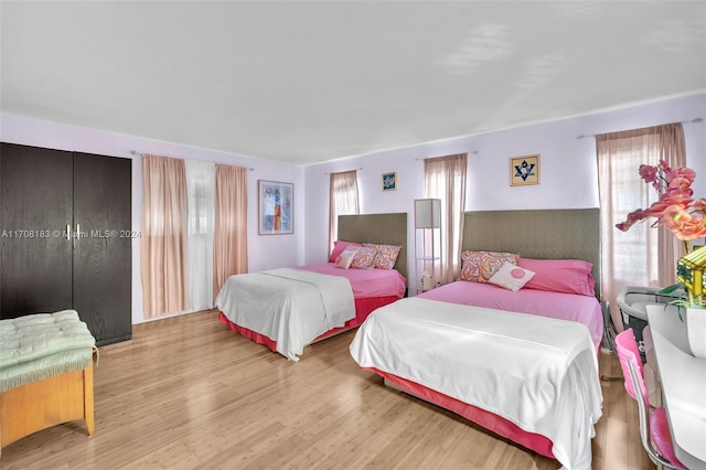 bedroom featuring light hardwood / wood-style floors and multiple windows