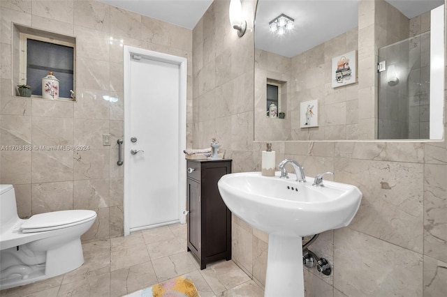 bathroom with sink, walk in shower, tile patterned flooring, toilet, and tile walls