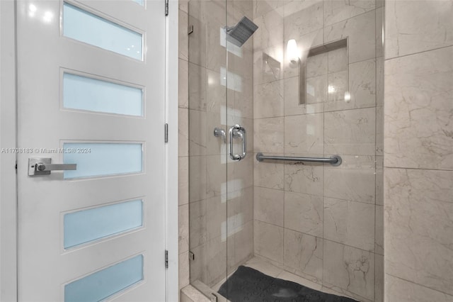 bathroom with a shower with door