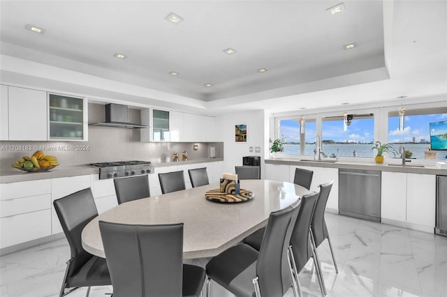 dining room with a raised ceiling and sink