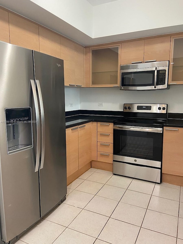 kitchen with light tile patterned floors, light brown cabinetry, and appliances with stainless steel finishes