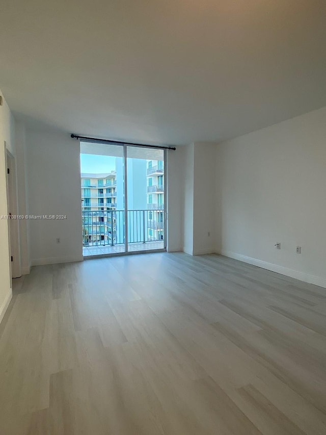 spare room featuring light hardwood / wood-style flooring and expansive windows