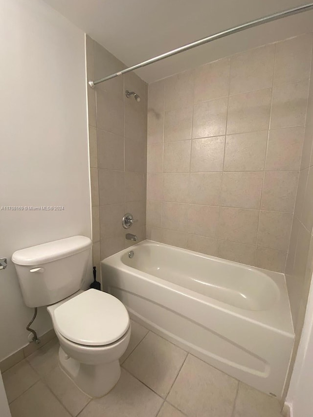 bathroom featuring toilet, tile patterned floors, and tiled shower / bath