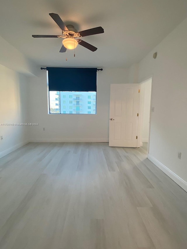 empty room with light wood-type flooring and ceiling fan