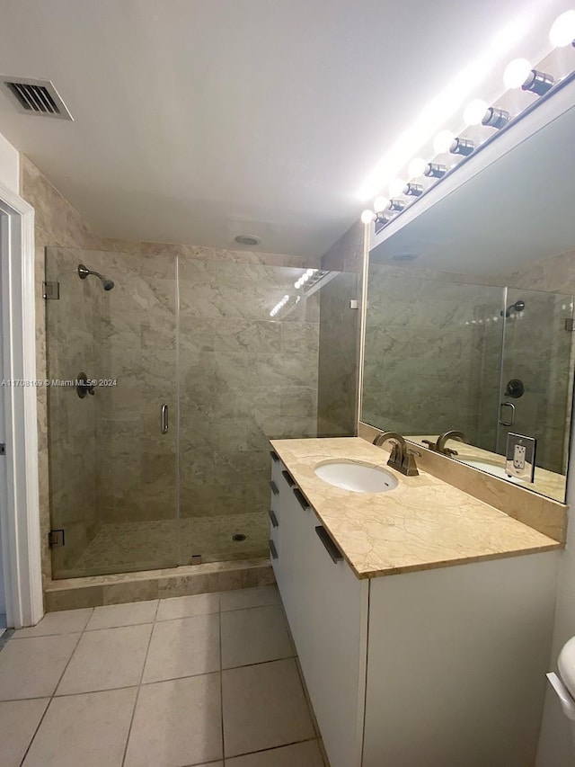 bathroom with tile patterned flooring, vanity, toilet, and walk in shower