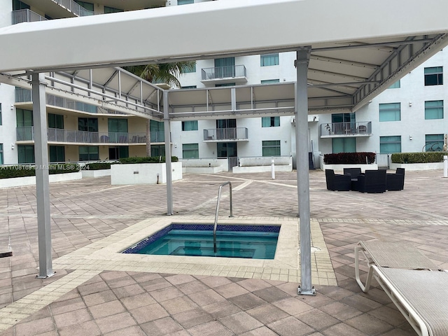 view of swimming pool with a community hot tub, an outdoor living space, and a patio