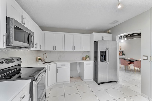 kitchen featuring white cabinetry, a textured ceiling, and appliances with stainless steel finishes