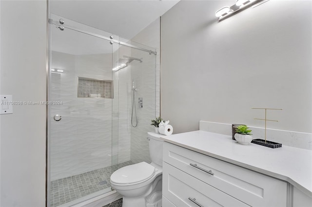 bathroom featuring vanity, toilet, and a shower with door