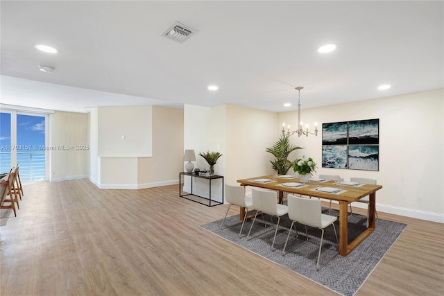 dining space featuring a chandelier, recessed lighting, baseboards, wood finished floors, and visible vents