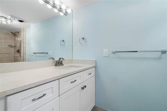full bathroom featuring vanity and tiled shower