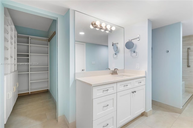 bathroom featuring tile patterned flooring, a shower, and vanity