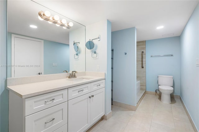 bathroom featuring tile patterned flooring, a tile shower, vanity, and toilet