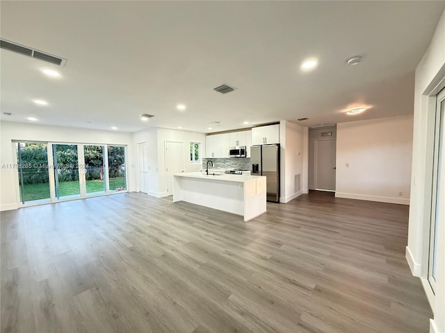 unfurnished living room with light hardwood / wood-style floors and sink