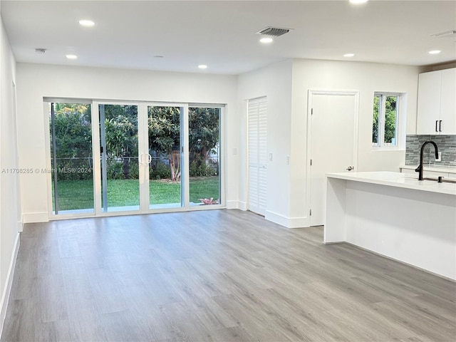 unfurnished living room featuring light hardwood / wood-style flooring and sink