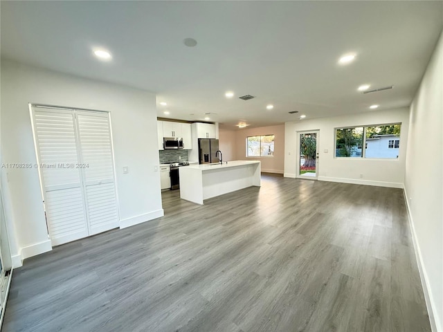 unfurnished living room featuring hardwood / wood-style floors and sink