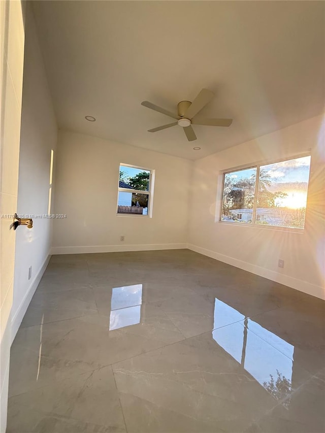 unfurnished room with ceiling fan and a healthy amount of sunlight