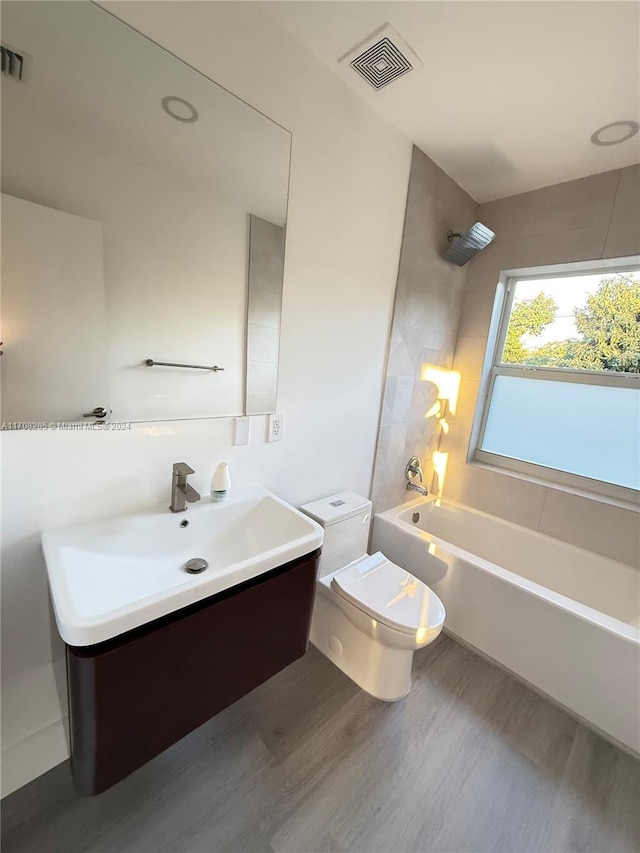 full bathroom featuring vanity, toilet, wood-type flooring, and shower / washtub combination