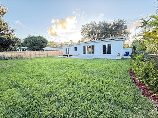 rear view of property with a yard