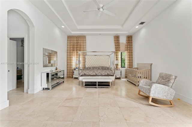 bedroom with a raised ceiling and ceiling fan