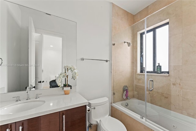 full bathroom featuring vanity, enclosed tub / shower combo, and toilet