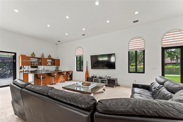 living room with bar area and light tile patterned floors