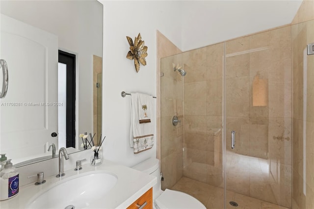 bathroom featuring toilet, an enclosed shower, and vanity