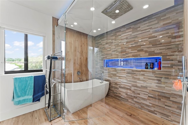 bathroom with wood-type flooring and a tub