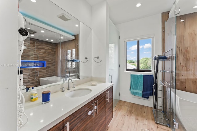 bathroom with vanity, hardwood / wood-style floors, and a bathtub