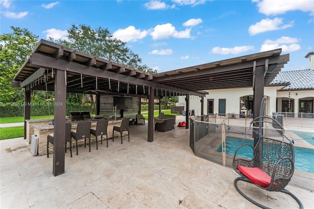 view of pool with exterior bar, a patio area, and a grill