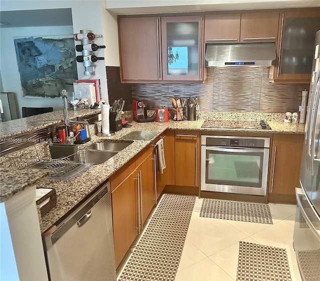 kitchen with ventilation hood, sink, light tile patterned floors, appliances with stainless steel finishes, and tasteful backsplash