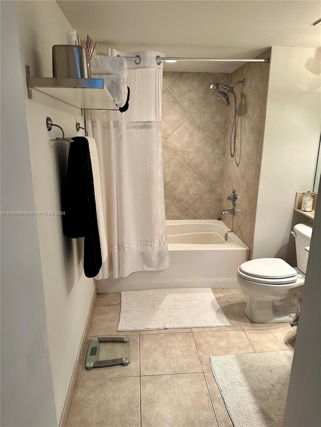 bathroom featuring tile patterned flooring, shower / tub combo, and toilet