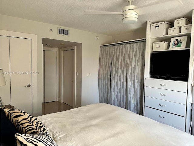 bedroom featuring a textured ceiling, a closet, and ceiling fan