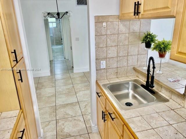 kitchen with light brown cabinets, sink, decorative backsplash, tile counters, and light tile patterned flooring