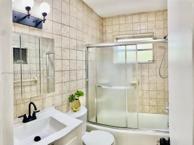 full bathroom featuring decorative backsplash, vanity, enclosed tub / shower combo, and toilet