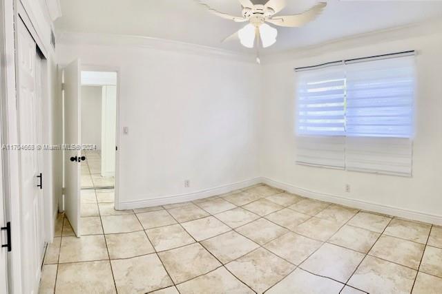 unfurnished room with light tile patterned floors, ceiling fan, and crown molding