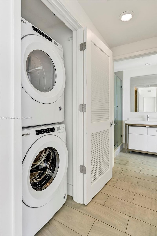 washroom featuring sink and stacked washer / dryer