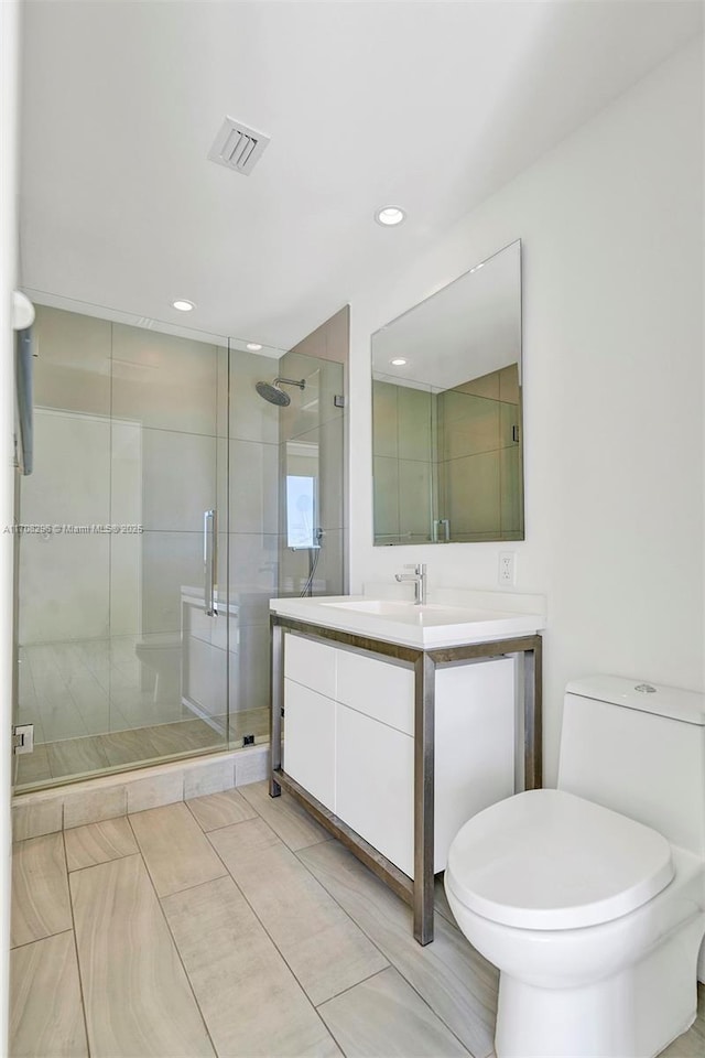 bathroom with tile patterned floors, toilet, vanity, and walk in shower