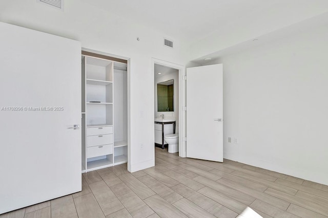 unfurnished bedroom with sink, a closet, and light wood-type flooring