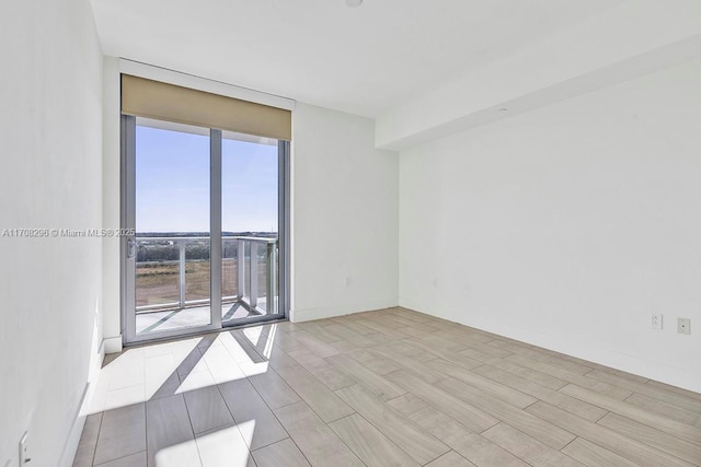 unfurnished room featuring light hardwood / wood-style flooring and expansive windows