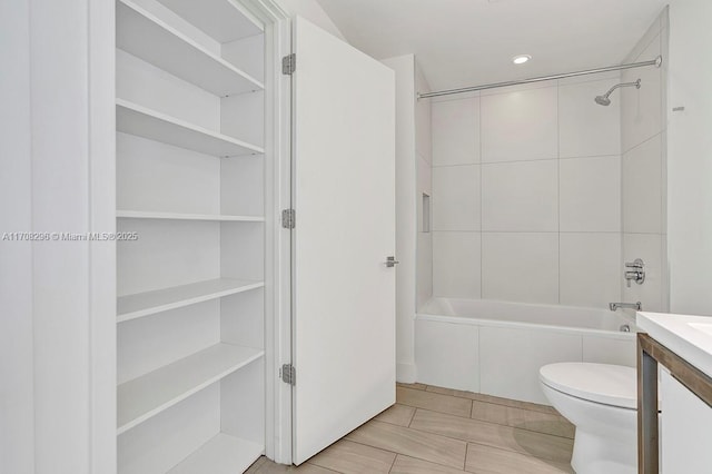 full bathroom featuring toilet, vanity, and tiled shower / bath combo