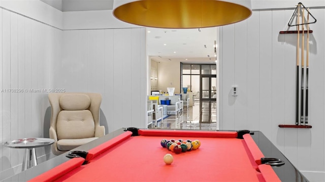 recreation room with wooden walls and pool table